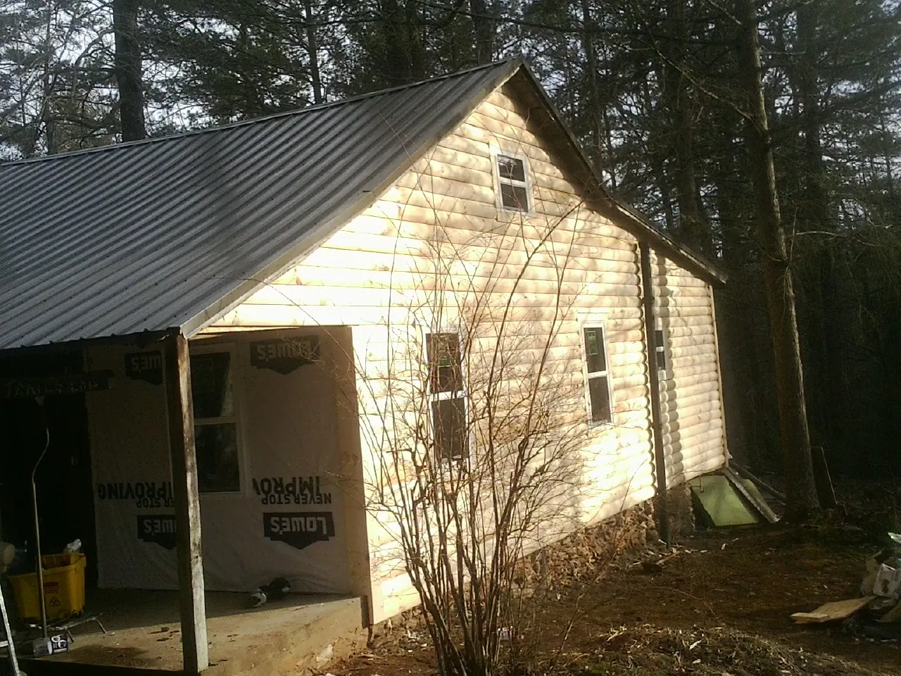 Log siding gable end under a dark metal roof edge in Niagara