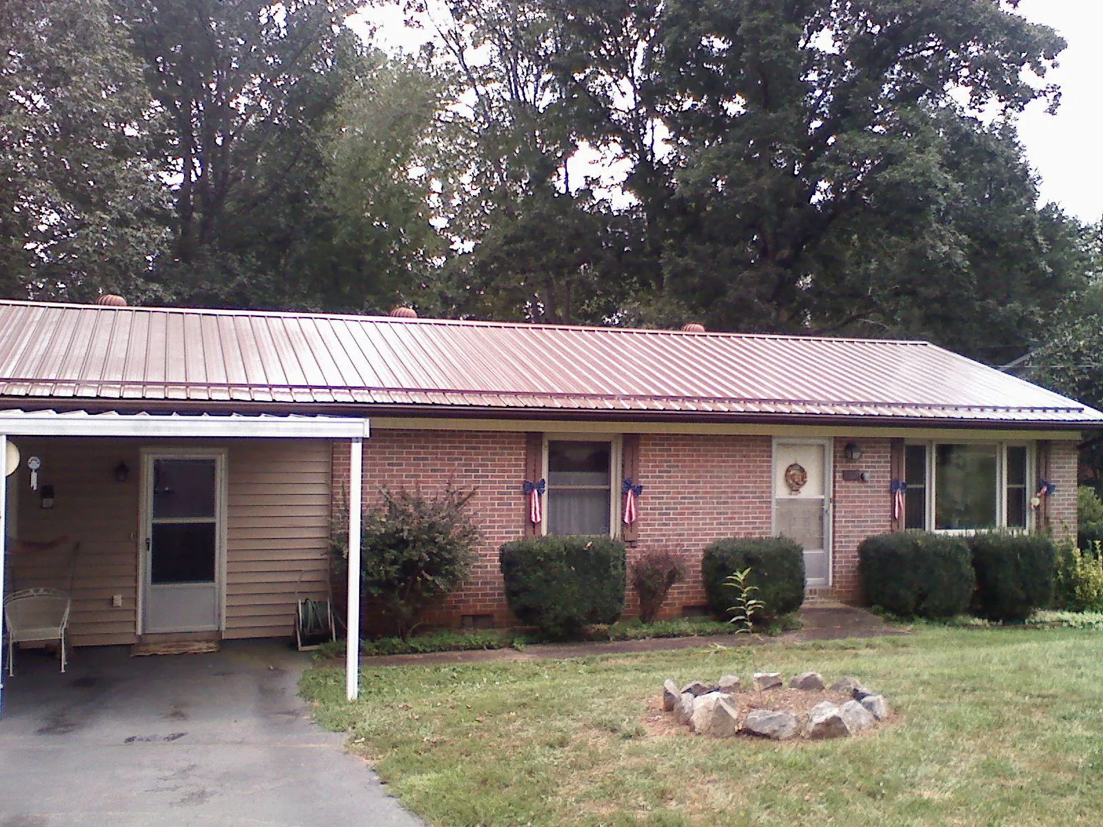 Bronze metal roof and carport on a brick ranch home — Roof Repair work by our crew in Niagara