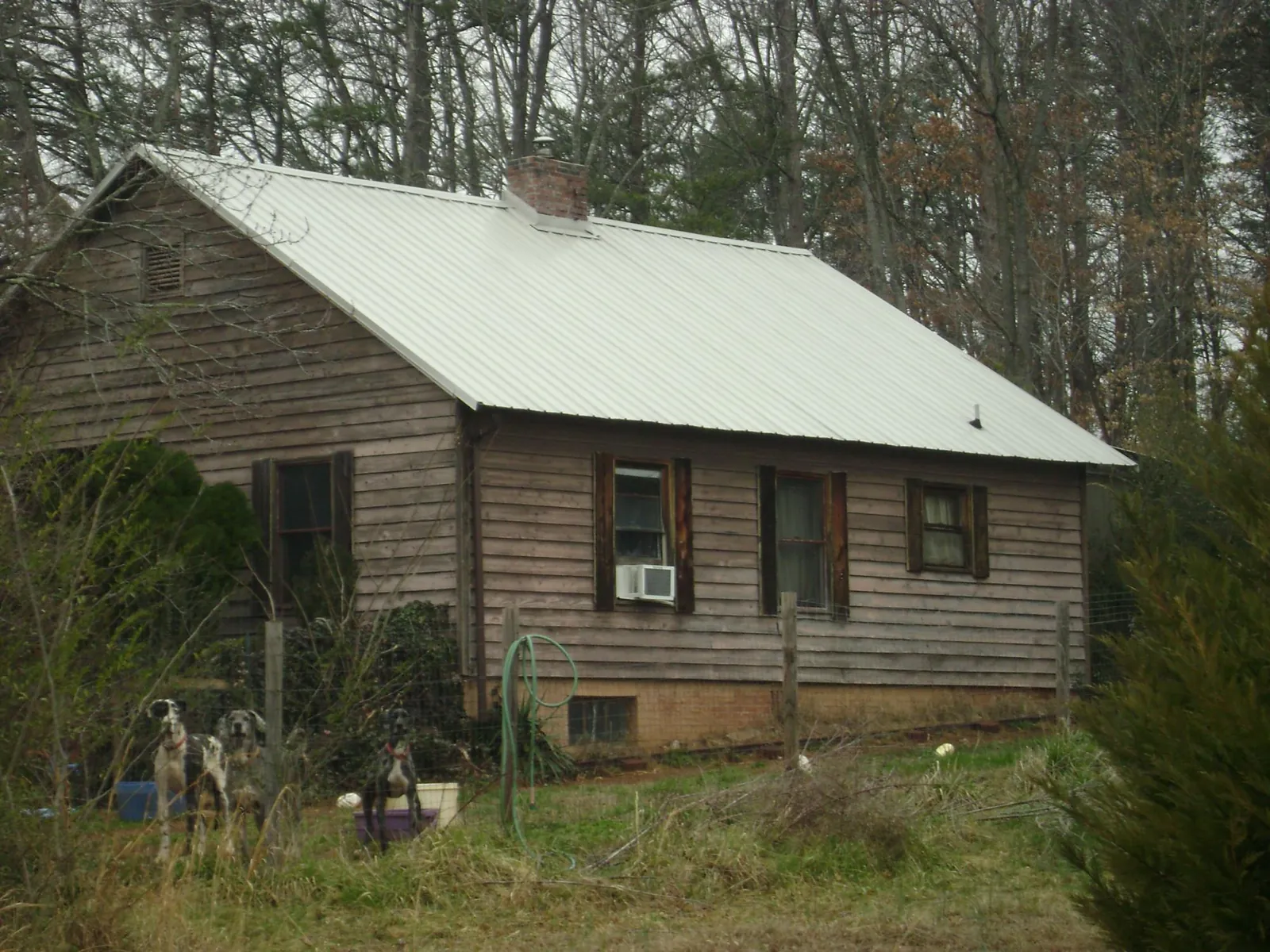 White metal roof on an old wood sided farmhouse, from a Metal Roof Installation job in Niagara